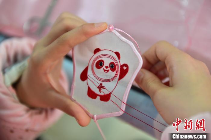 圖為一名小學生正在繡制2022年北京冬奧會吉祥物“冰墩墩”形象。 喻云亮 攝