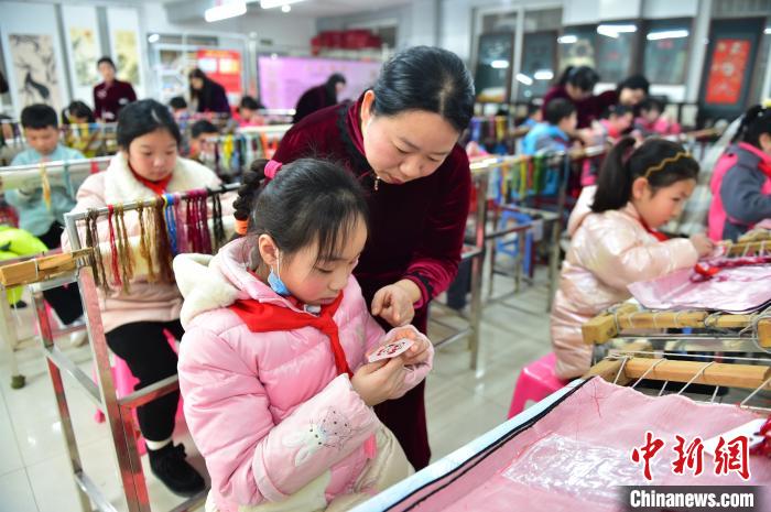 江西省級非遺豫章繡傳承人手把手指導小學生繡制2022年北京冬奧會吉祥物“冰墩墩”形象。 喻云亮 攝