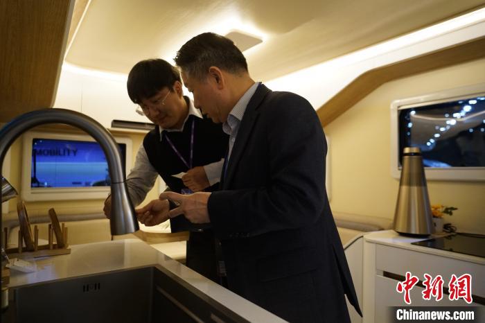 圖為參展商向觀眾介紹房車內部設計。　劉旭 攝