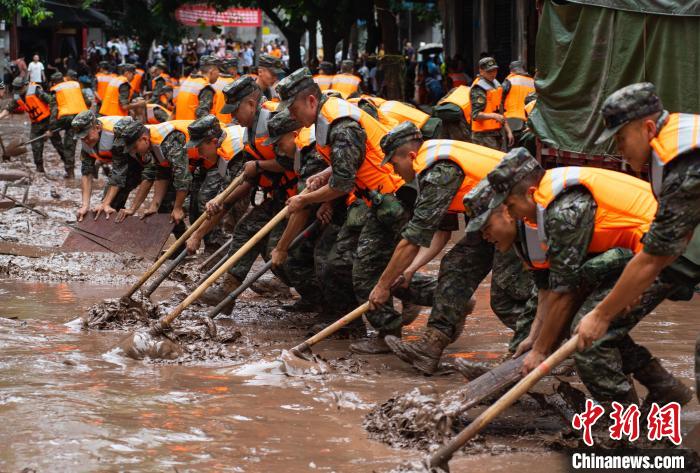 7月4日,萬州區(qū)五橋街道,武警官兵清理街道上的淤泥。 冉孟軍 攝
