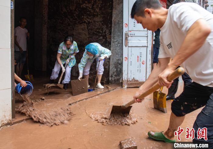 7月4日,萬州區(qū)五橋街道,洪水退去后,居民開展清淤工作。 冉孟軍 攝