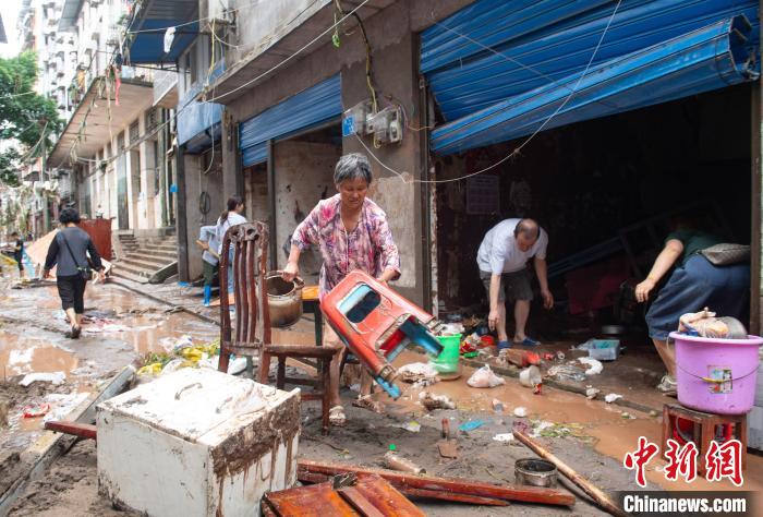 7月4日,萬州區(qū)五橋街道,洪水退去后,居民搶救生活物資。 冉孟軍 攝