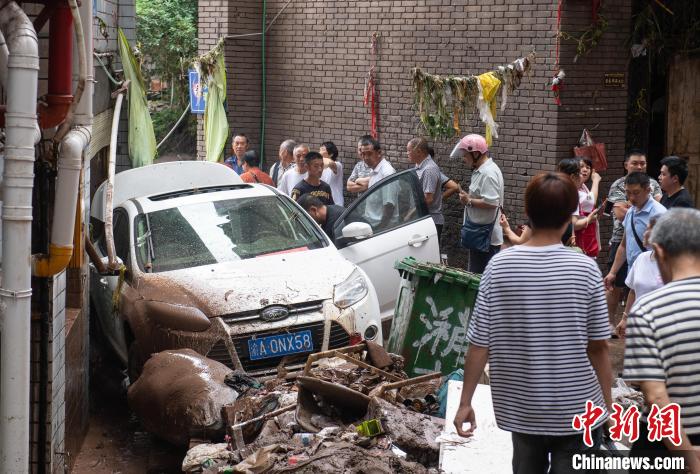 7月4日,萬州區(qū)五橋街道,居民救援受困的私家車。 冉孟軍 攝