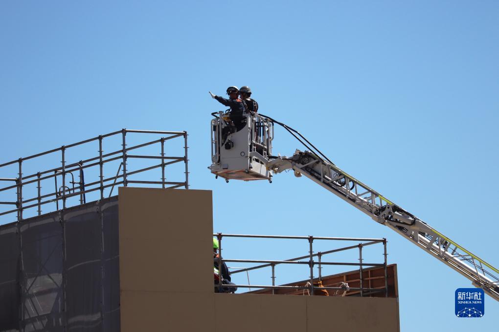 9月1日，在日本神奈川縣相模原市，消防員演練用消防云梯車(chē)救下被困高樓的民眾。9月1日是日本防災(zāi)日。當(dāng)天，日本中央政府及多個(gè)都縣市舉行了防災(zāi)演練，以提高大規(guī)模災(zāi)害發(fā)生時(shí)防災(zāi)機(jī)構(gòu)和市民迅速應(yīng)對(duì)的能力。新華社記者 楊光 攝