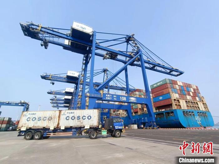 圖為海南洋浦國際集裝箱碼頭，卡車將集裝箱從后方堆場運往碼頭裝卸區(qū)。　張月和 攝