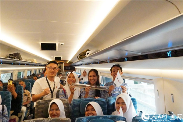 第一次乘坐雅萬高鐵動車組的學生們與動車組模型合影。人民網記者曹師韻攝