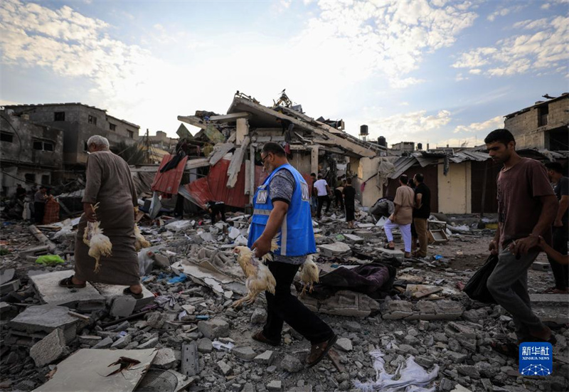 10月27日，在加沙地帶南部城市汗尤尼斯，人們經過以軍襲擊后的房屋廢墟。