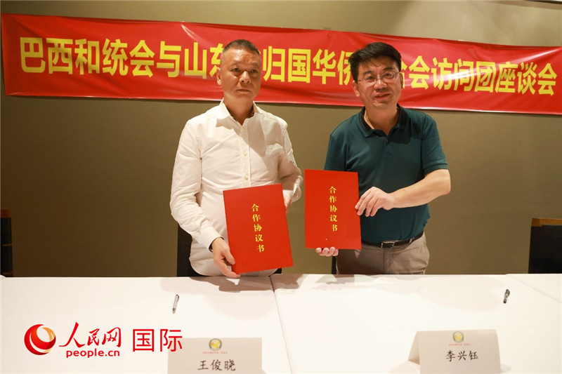 中國(guó)僑聯(lián)副主席、山東省僑聯(lián)主席李興鈺（右）與巴西和統(tǒng)會(huì)會(huì)長(zhǎng)王俊曉簽署合作協(xié)議書(shū)。人民網(wǎng)記者 陳海琪攝