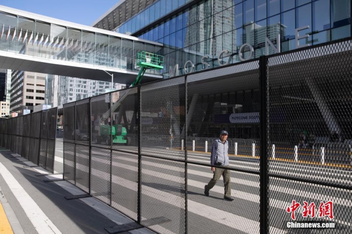 當(dāng)?shù)貢r(shí)間11月10日，一名行人從美國舊金山莫斯康中心周圍的金屬圍欄旁經(jīng)過。隨著亞太經(jīng)合組織(APEC)第三十次領(lǐng)導(dǎo)人非正式會(huì)議臨近，作為會(huì)議場地的莫斯康中心附近出現(xiàn)金屬圍欄，執(zhí)勤警察也大幅增加。<a target='_blank' href='/'><p  align=