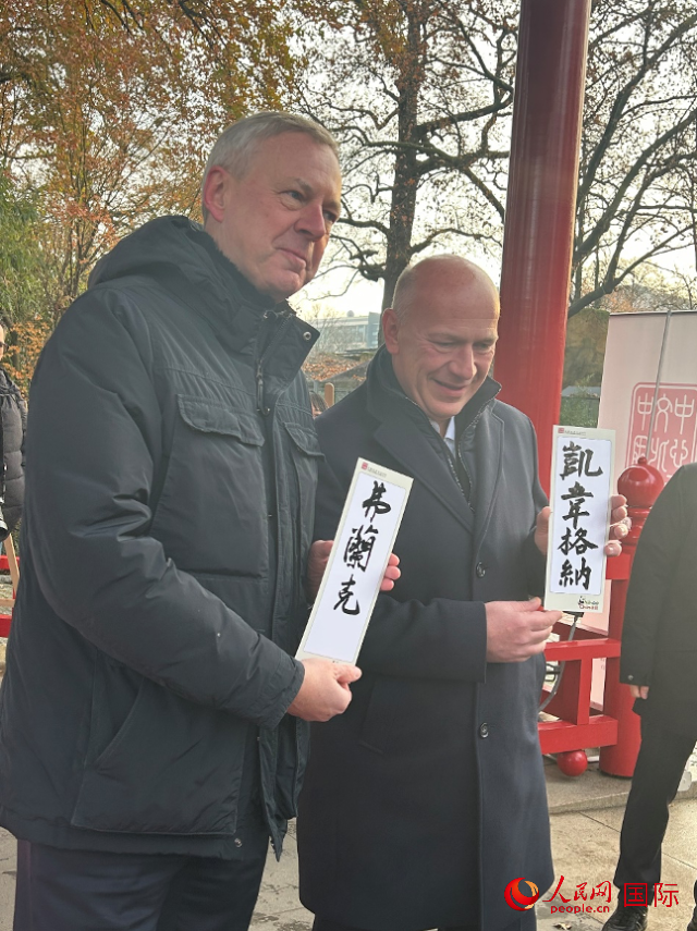 柏林市長韋格納（右）、動物園監事會主席布魯克曼（左）手持中國文化中心工作人員現場手書的中文名字。人民網記者 徐馨攝