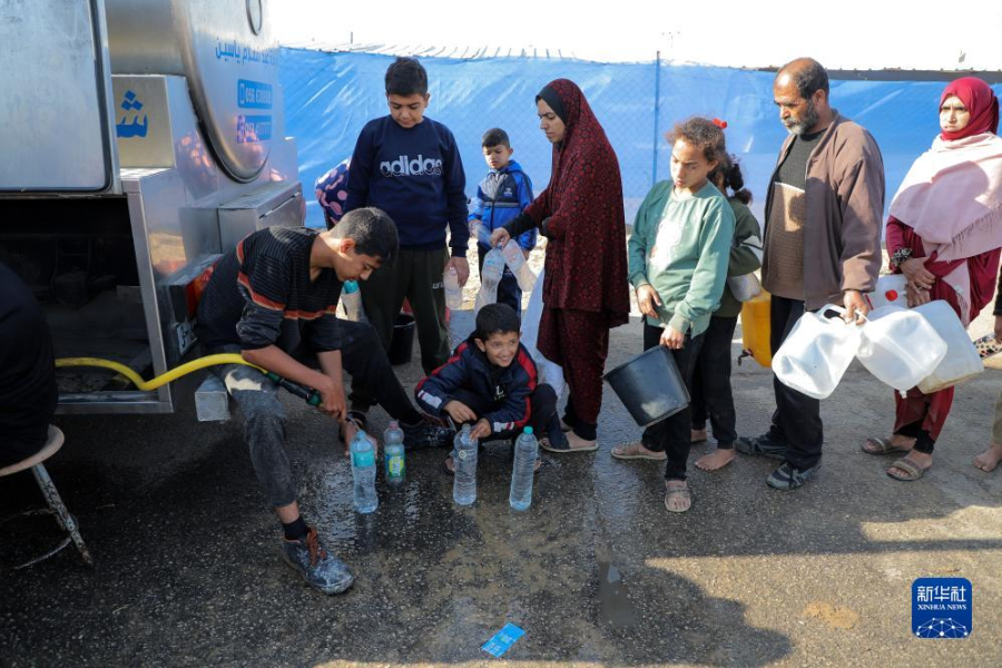 12月8日，在加沙地帶南部城市拉法一處臨時營地內，人們排隊打水。新華社發（里澤克·阿卜杜勒賈瓦德 攝）