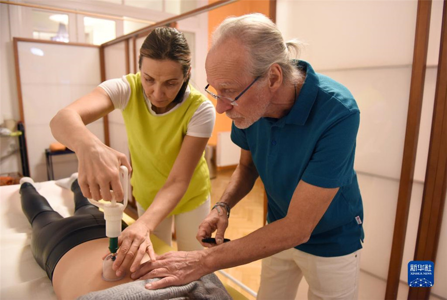 12月12日，在奧地利維也納，科格勒醫生（右）和助手在為病人進行拔罐治療。新華社記者 賀燦鈴 攝