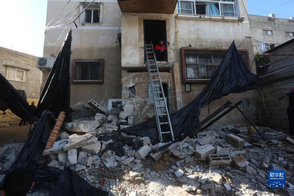 12月17日，在約旦河西岸城市圖勒凱爾姆附近的一處難民營，人們查看在沖突中損毀的房屋。新華社發(fā)（尼達爾·艾仕塔耶攝）