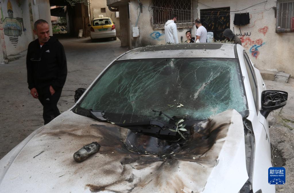 12月17日，在約旦河西岸城市圖勒凱爾姆附近的一處難民營，人們查看在沖突中損毀的車輛。新華社發(fā)（尼達爾·艾仕塔耶攝）