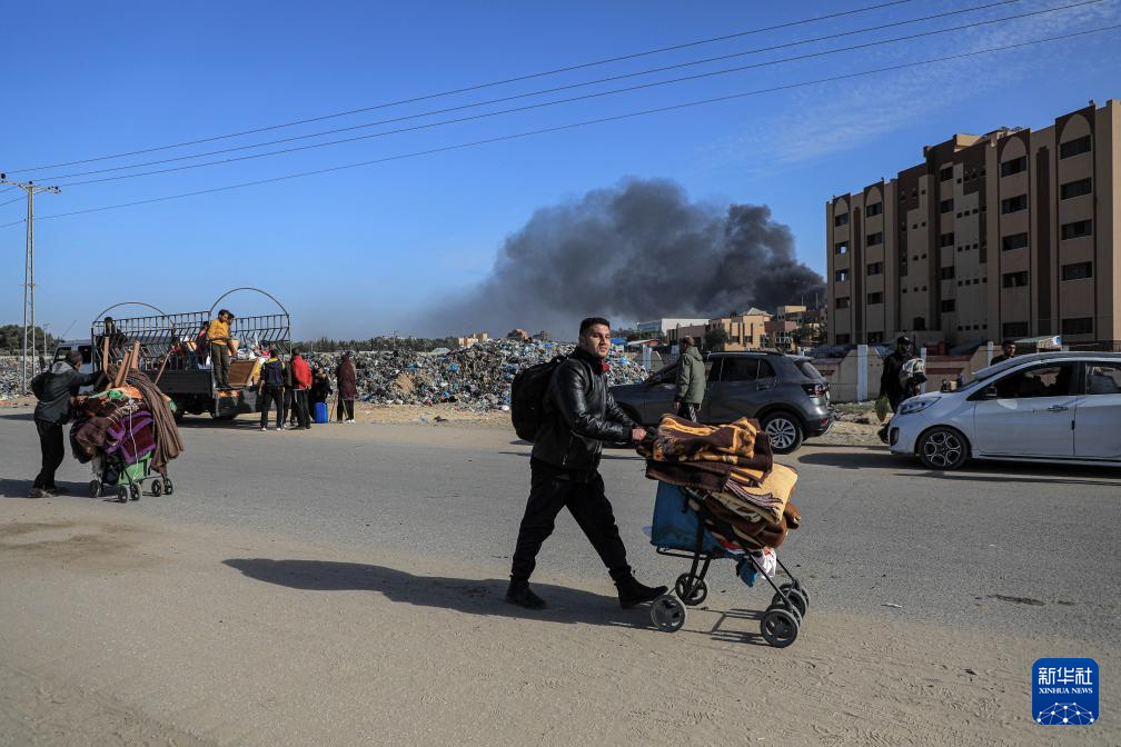 1月22日,在加沙地帶南部城市汗尤尼斯,人們逃離家園。新華社發(里澤克·阿卜杜勒賈瓦德攝)