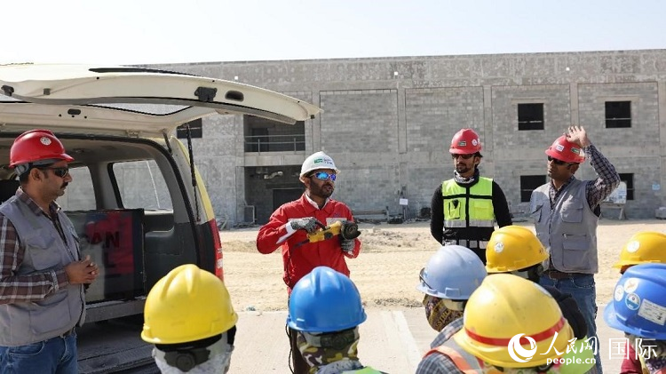 穆薩瓦爾(圖中紅衣人）現場演示工具操作規范。人民網記者 管克江攝