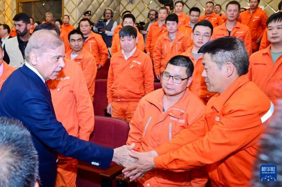 4月1日，在巴基斯坦西北部開伯爾-普什圖省達蘇，巴基斯坦總理夏巴茲（左）同達蘇水電站項目中方員工握手。新華社發(fā)（巴基斯坦新聞與廣播部下轄媒體信息部門供圖）