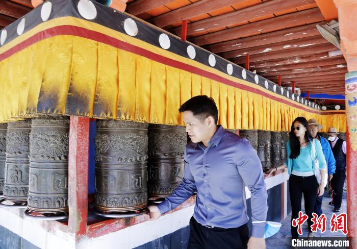 圖為外籍嘉賓體驗藏族傳統轉經筒?！●R銘言 攝