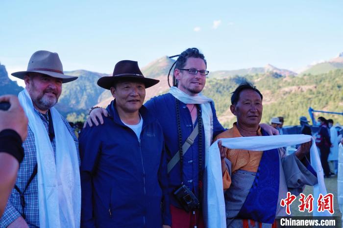 圖為當地民眾與外籍攝影師合影留念?！●R銘言 攝