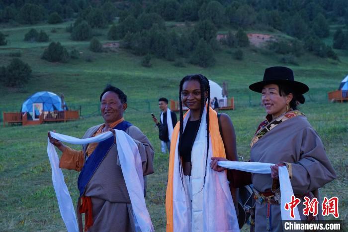 圖為當地民眾與外籍留學生合影留念?！●R銘言 攝