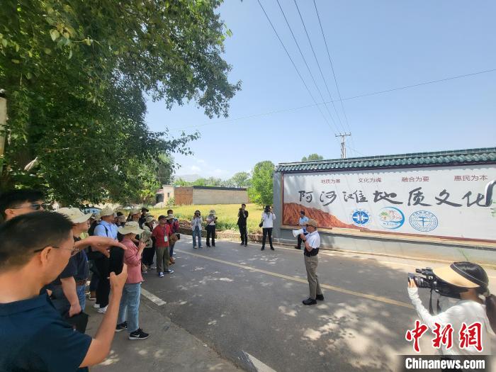 圖為中國地質(zhì)大學(xué)(北京)教授張緒教介紹村落情況?！『衍?攝