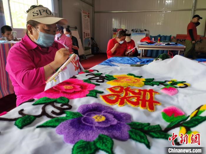 圖為婦女制作青繡?！?zhí)砀?攝