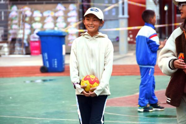 在高原上教孩子們打手球，“慢慢兒來，甭著急！”