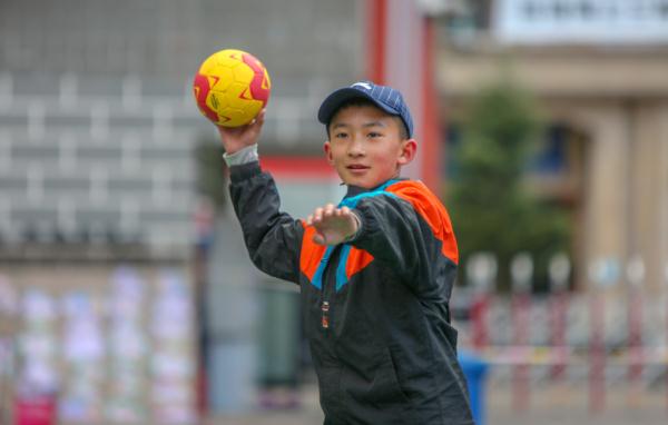 在高原上教孩子們打手球，“慢慢兒來，甭著急！”