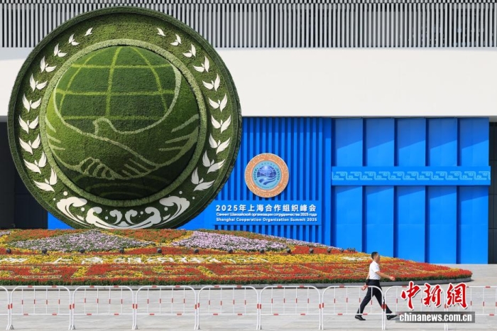 8月31日，天津，一名工作人員從2025年上海合作組織峰會主會場外的景觀花壇旁經過。當日，2025年上海合作組織峰會在天津舉行。<a target='_blank' href='/'><p  align=