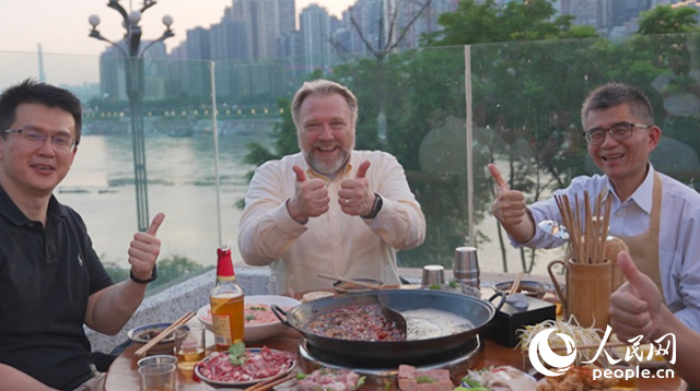 康寧顯示科技事業(yè)部全球拓建項目總監(jiān)軻寶華(中)和同事在重慶南濱路吃火鍋。人民網(wǎng)記者 蘇纓翔攝