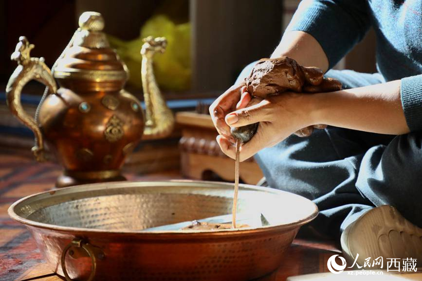 牛角鉆孔,將木泥擠出。人民網記者 次仁羅布攝