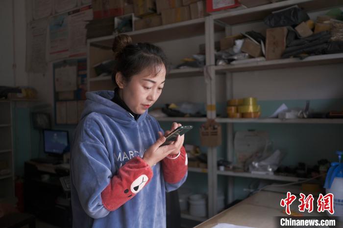 正在快遞站點內忙碌的楊莉春。 何蓬磊 攝