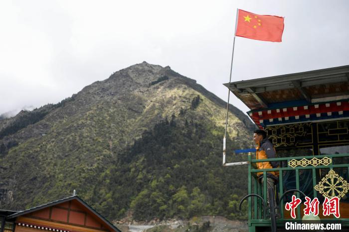 村民站在樓房上觀望。 楊華峰 攝