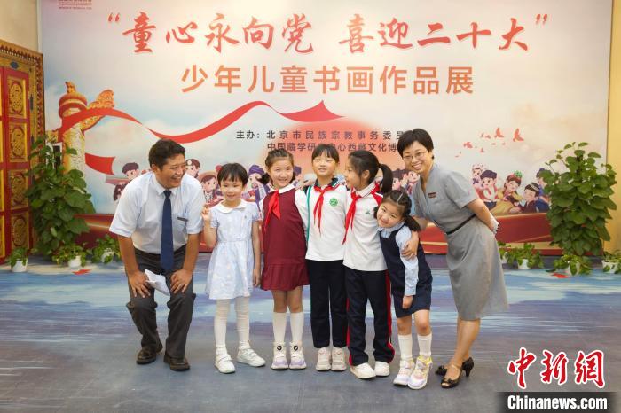 圖為與會嘉賓與入選畫作的“小作者”們在展覽上合影?！≈袊貙W研究中心供圖