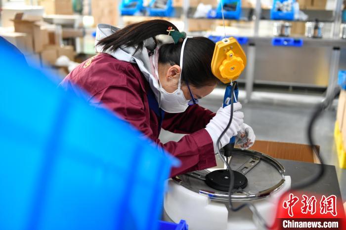 圖為工人正在組裝炊具。 貢嘎來松 攝