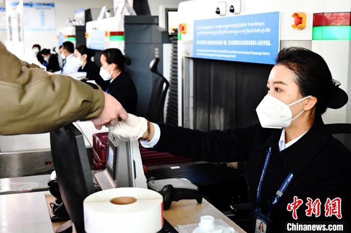 圖為機(jī)場(chǎng)工作人員為旅客辦理行李托運(yùn)。　周航 攝