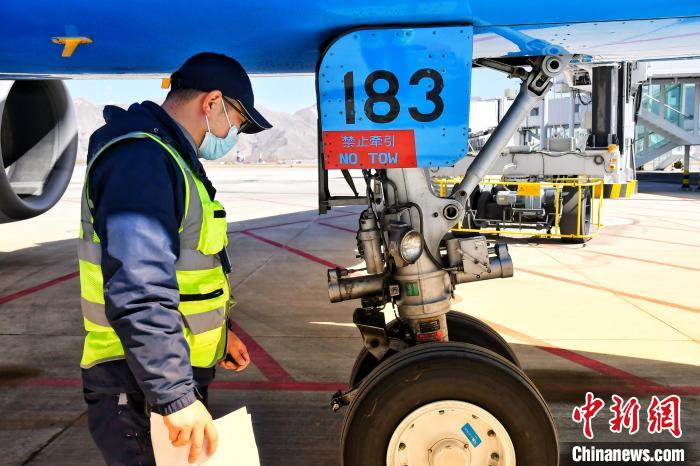 圖為機(jī)場(chǎng)工作人員進(jìn)行相關(guān)檢查?！≈芎?攝