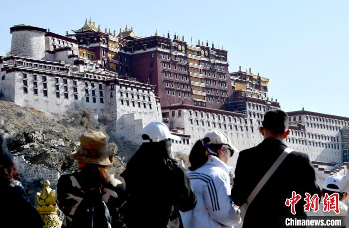 4月17日,游客在拉薩布達拉宮觀景臺拍照留念。 李林 攝