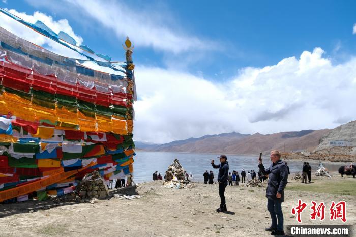 進藏參訪嘉賓在羊湖畔拍攝經幡。　江飛波 攝