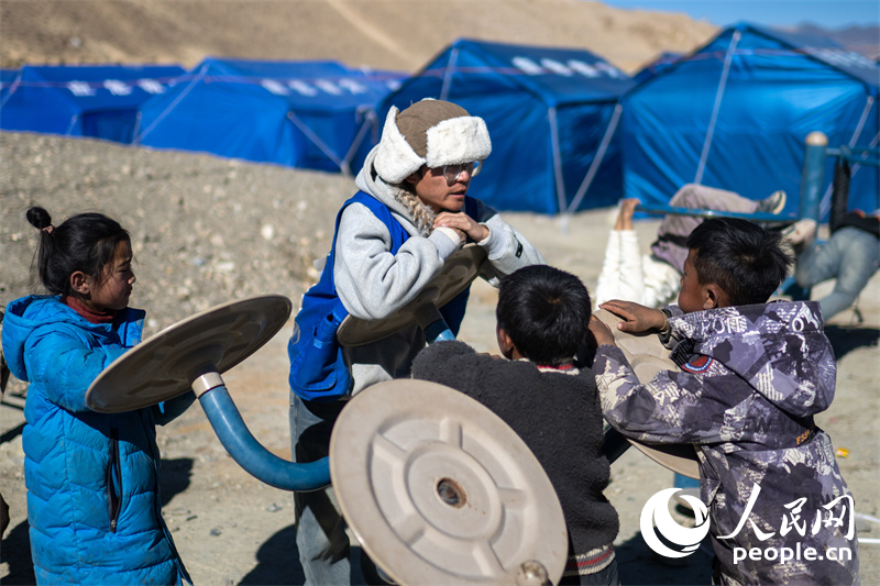 西藏星光社會工作服務中心社工久米旦增通過聊天談心，對孩子們進行災后心理疏導。人民網記者 翁奇羽攝